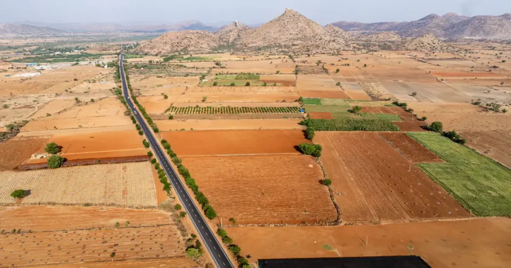 Aerial view of farmland plots and road access for buyers comparing farmland near Hosur